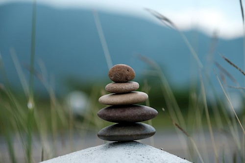 Stacked stones in front of a serene nature background